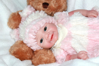 A teddy bear rests next to a baby doll, highlighting a sweet and innocent moment in a child's playtime.